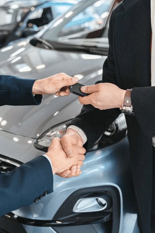 A vehicle key being handed to a customer