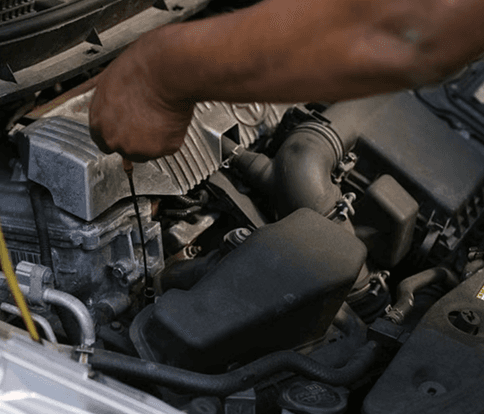 A mechanic servicing a vehicle engine